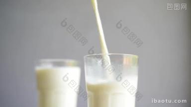 在<strong>模糊</strong>的<strong>背景</strong>下把牛奶倒入玻璃杯.